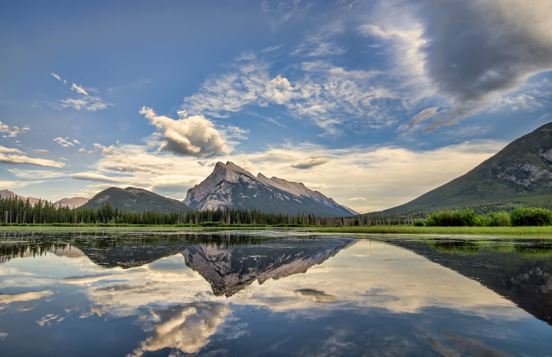 body of water near mountain peaks