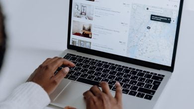 person using macbook pro on white table