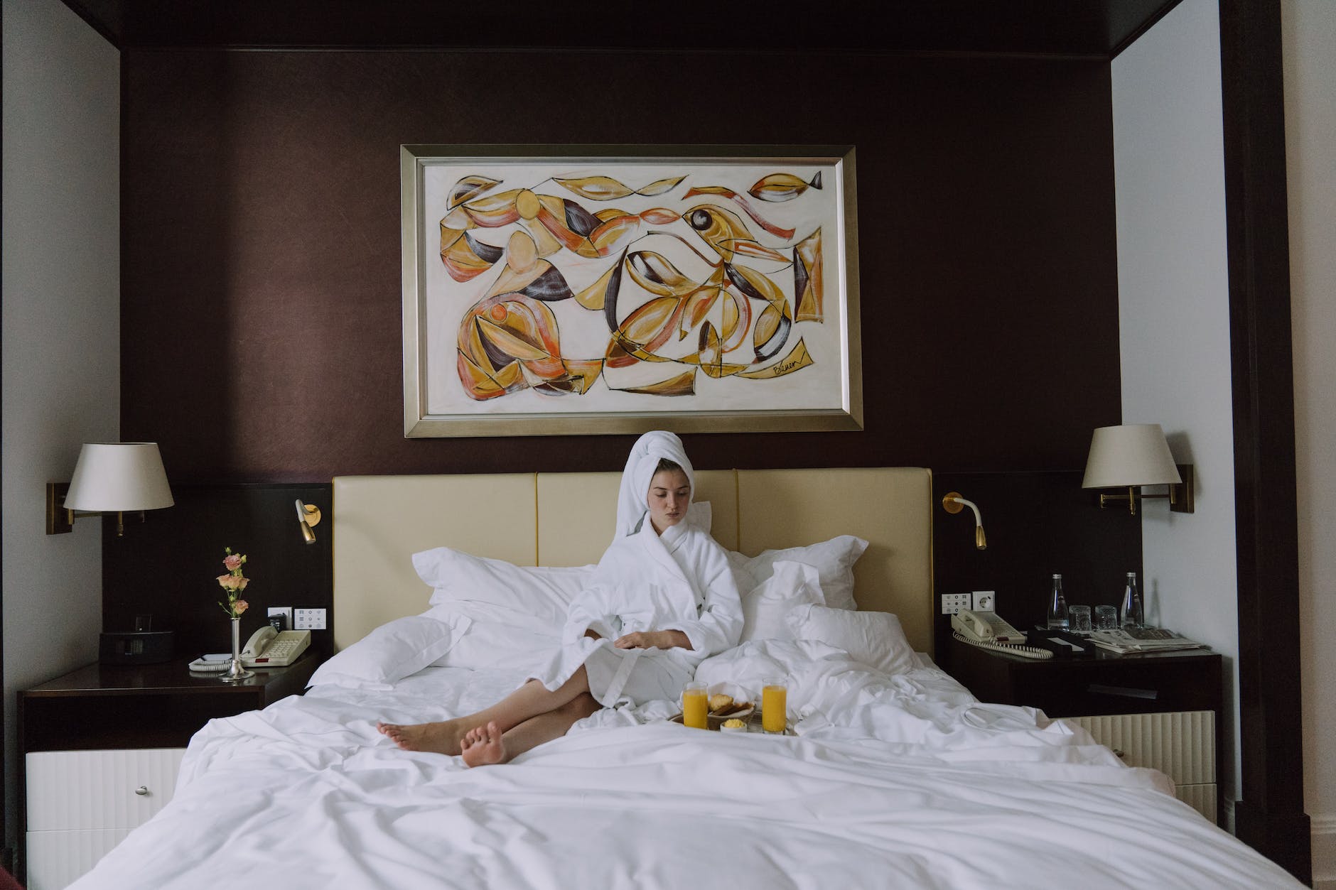 woman in bathrobe sitting on bed