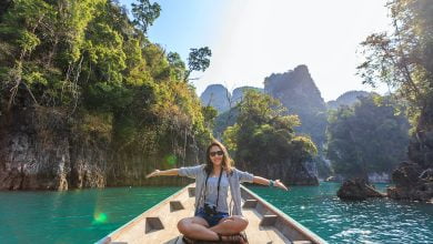 photo of woman sitting on boat spreading her arms