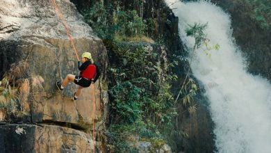 woman rocking climbing near waterfalls