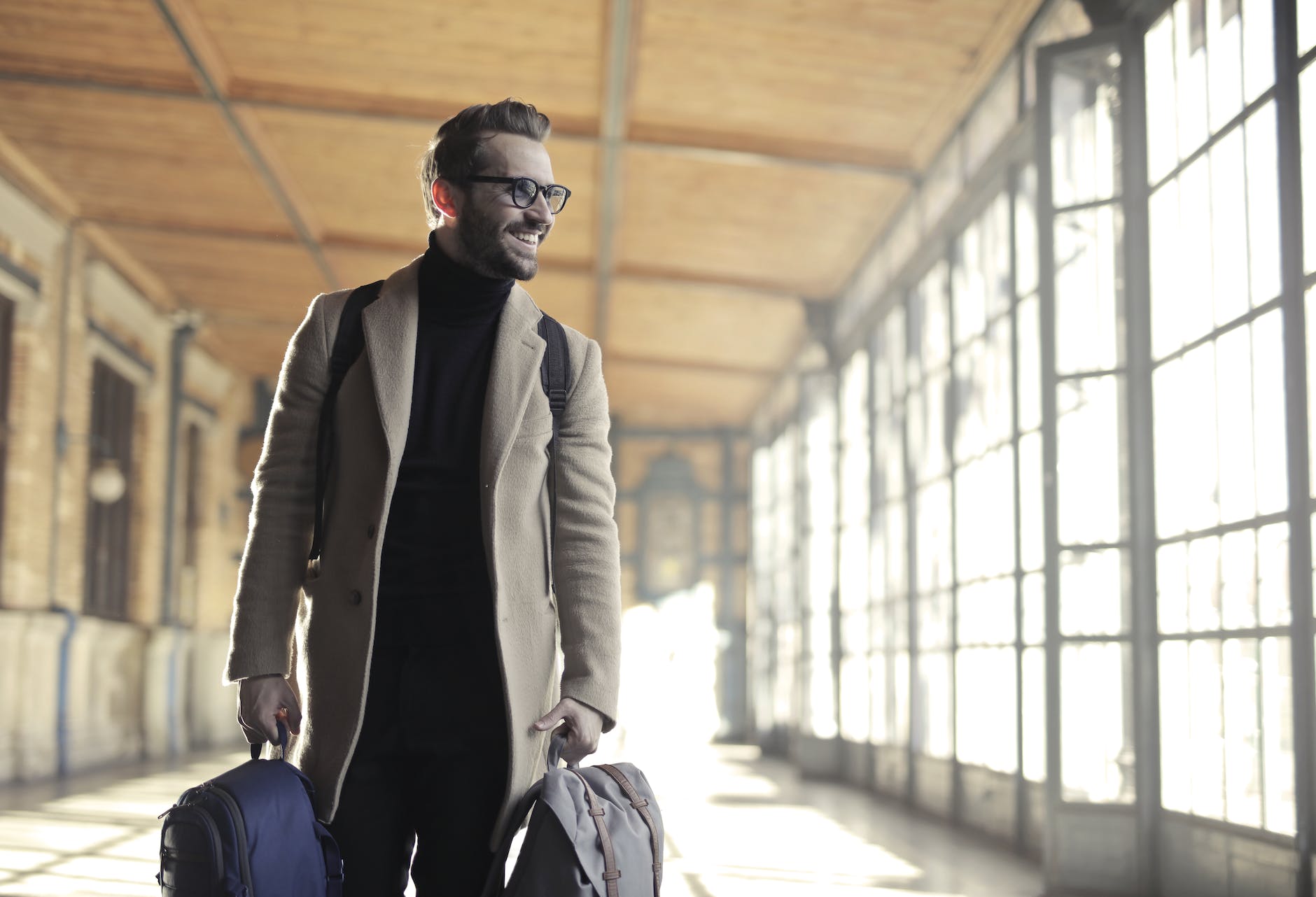 man in brown robe carrying bag smiling